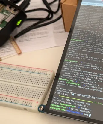 Auf einem Tisch steht ein prototypischer Aufbau eines Touch-Displays mit Raspberry-Pi-Steuerung.
