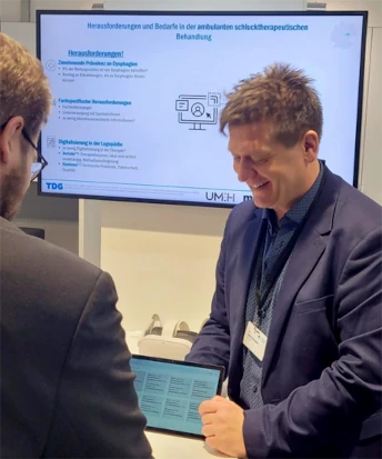 Daniel Brinschwitz erklärt einem Besucher einen dysphappgy-Prototypen auf der MEDICA