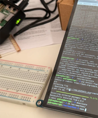 Auf einem Tisch steht ein prototypischer Aufbau eines Touch-Displays mit Raspberry-Pi-Steuerung.